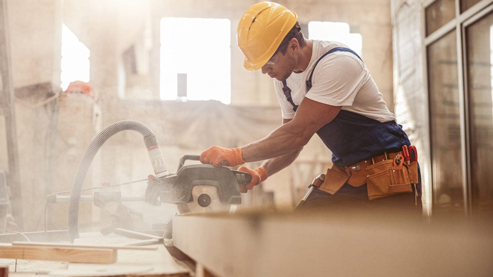 Licensed building practitioner using a circular saw on a NZ construction site