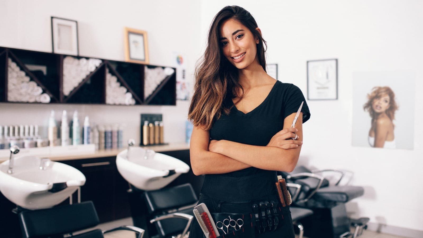 Hairdresser in a home salon with styling tools and equipment behind