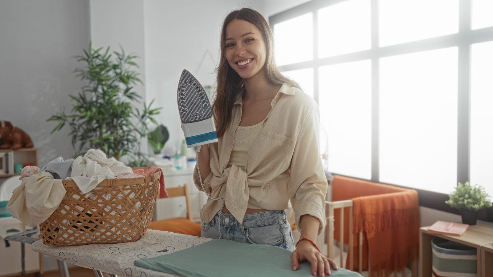 Mobile ironing operator at an ironing board with a laundry basket