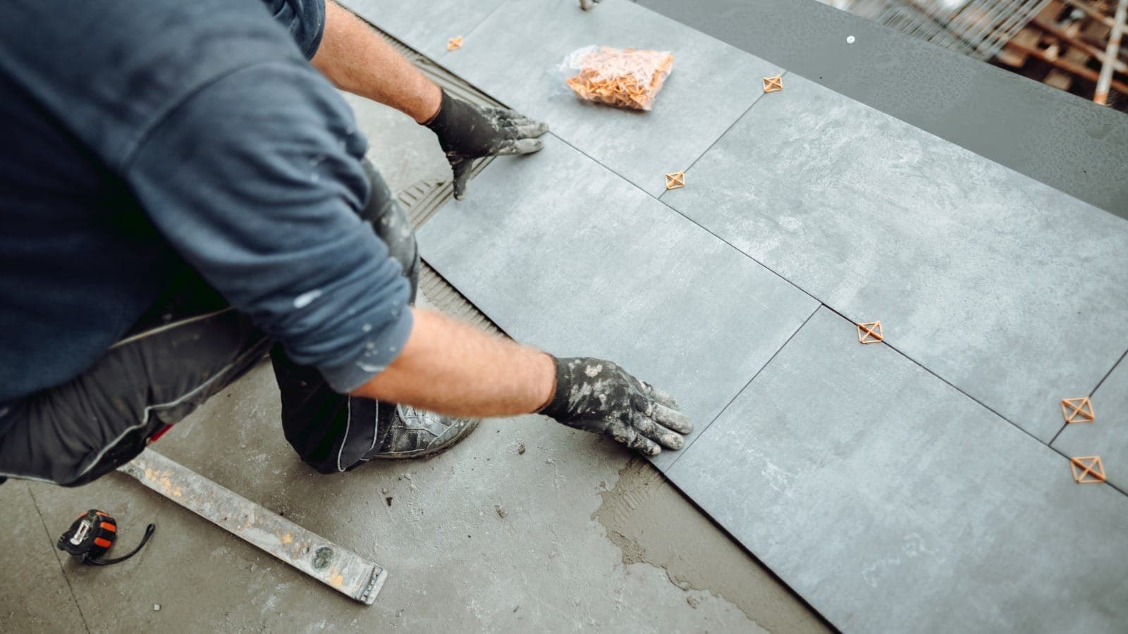 Tiler laying large floor tiles with spacers between them